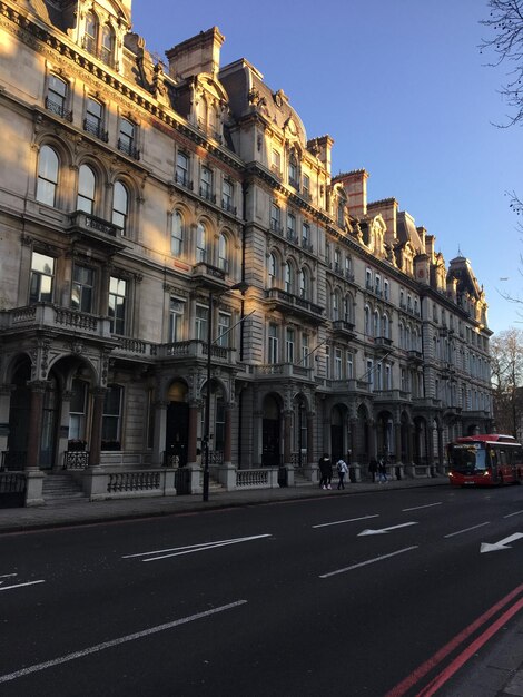 Photo road by buildings against sky in city