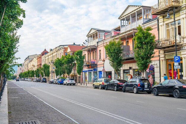 Road by buildings in city against sky