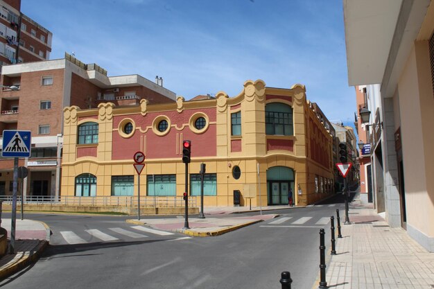 Road by buildings in city against sky