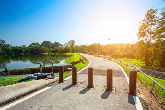 写真 晴れた日に澄んだ空に照らされた湖のそばの道