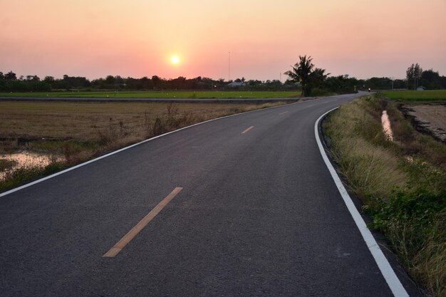 写真 夕暮れの空に照らされた風景の道路