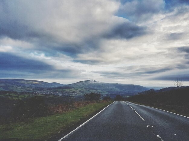 Road by landscape against sky