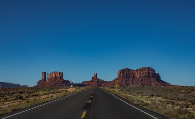 Photo road by mountain against clear blue sky