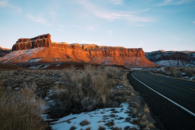 Road by mountain against sky during winter