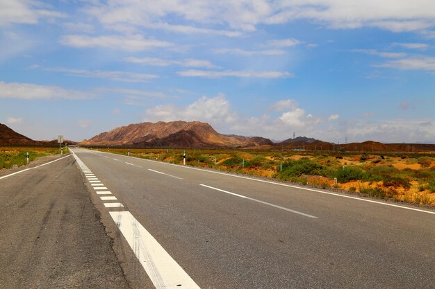 Road by mountain against sky