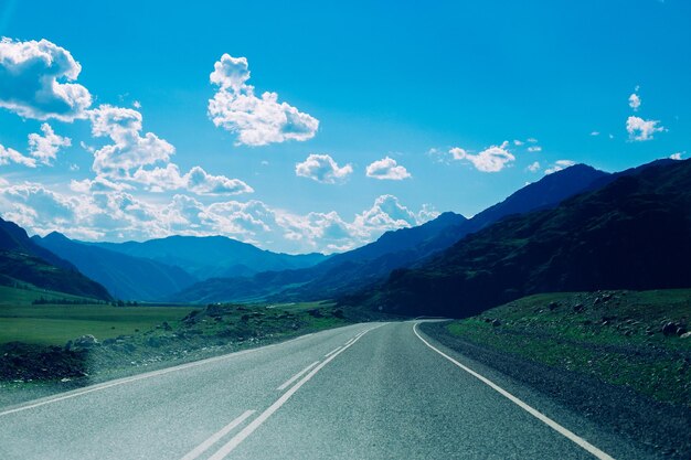 Road by mountains against blue sky