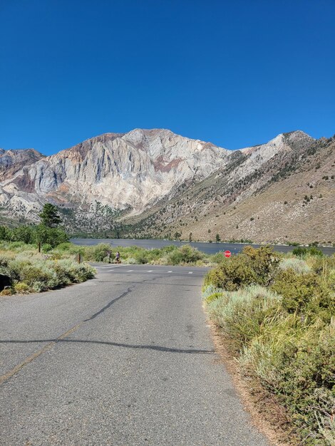 Road by mountains against clear blue sky