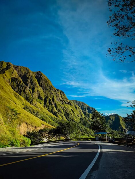 Road by mountains against sky