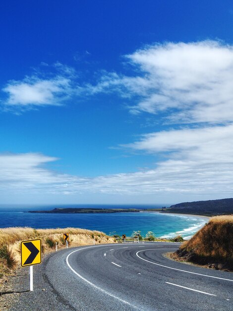 Road by sea against blue sky