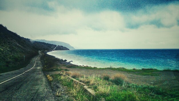 Road by sea against sky