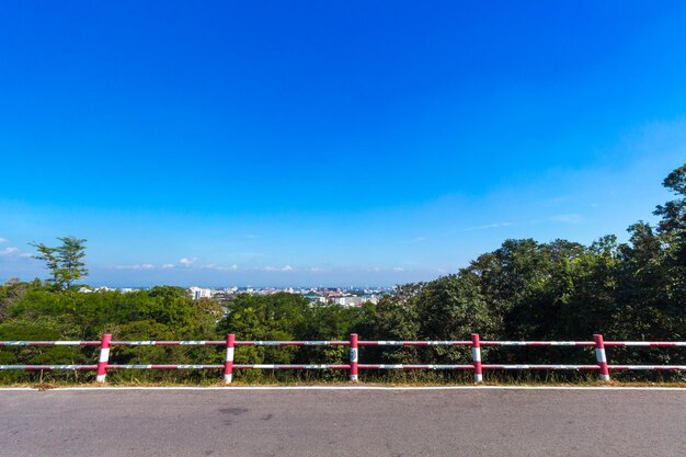 Road by trees against blue sky