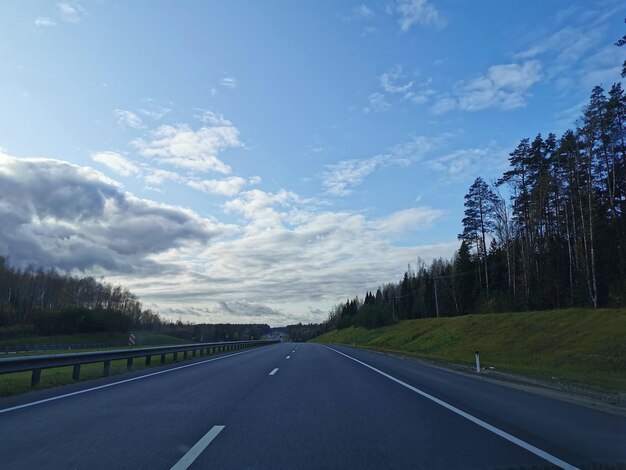 Photo road by trees against sky