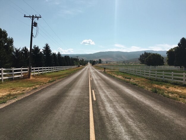 Photo road by trees against sky