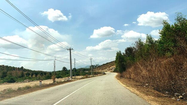 Photo road by trees against sky