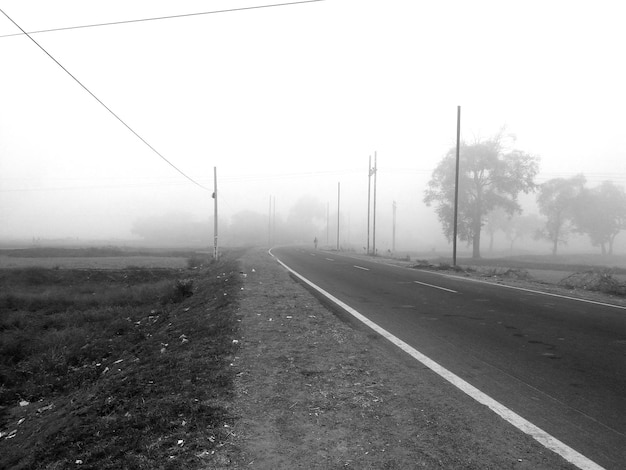 Photo road by trees against sky