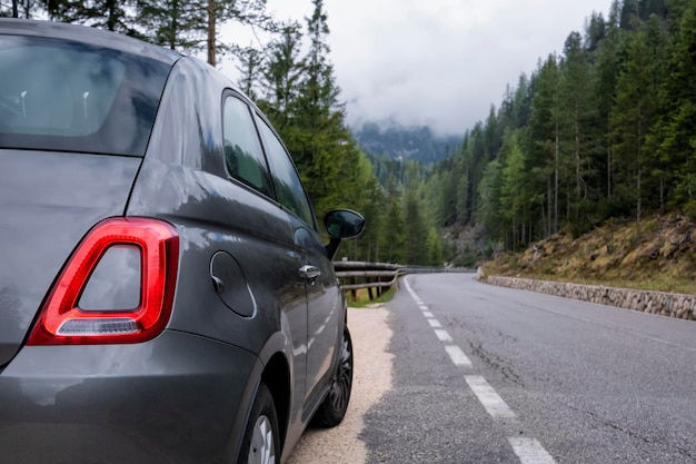 Road and car and Alpine mountains on the background May trip to South Tyrol in the Dolomites Northern Italy snow mountains