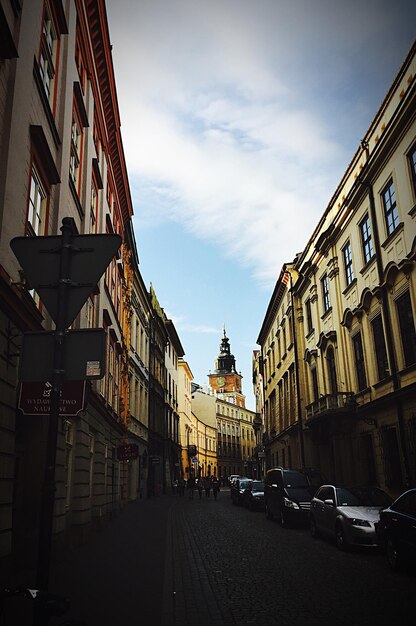 Road in city against cloudy sky