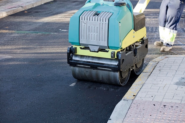 Road construction equipment flattening and smoothing asphalt black top lane