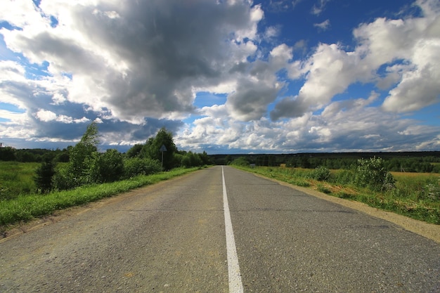 Foto strada nel paesaggio nuvoloso del campo