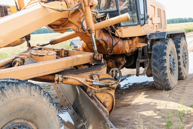 Livellatrice stradale - attrezzatura pesante per la costruzione di strade e lavori di sterro. livellamento e miglioramento della superficie del terreno. costruzione di strade e comunicazioni di trasporto.