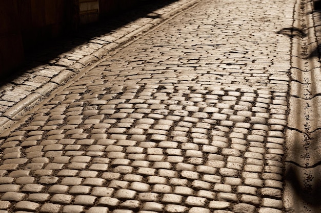 Photo the road is made of granite tiles in the rays of the sun