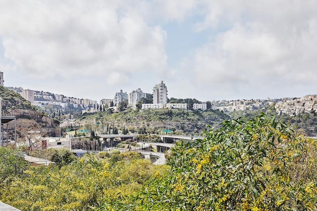 Road junction in Haifa city and city buildings in greenery in spring