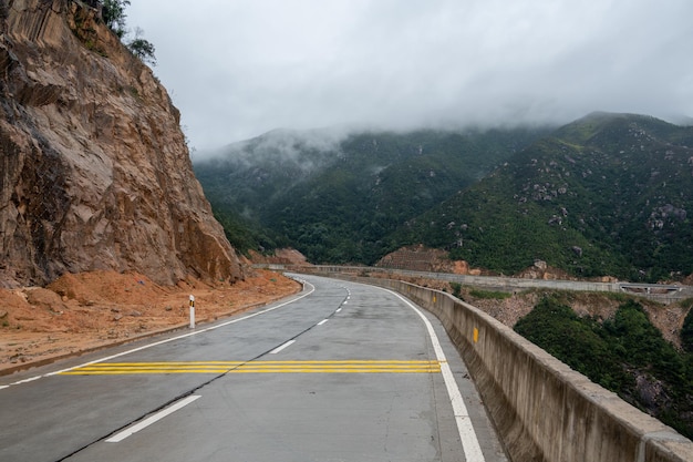 A road leading to the mountains There is fog on the mountains