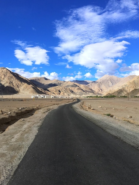 Road leading towards desert against sky