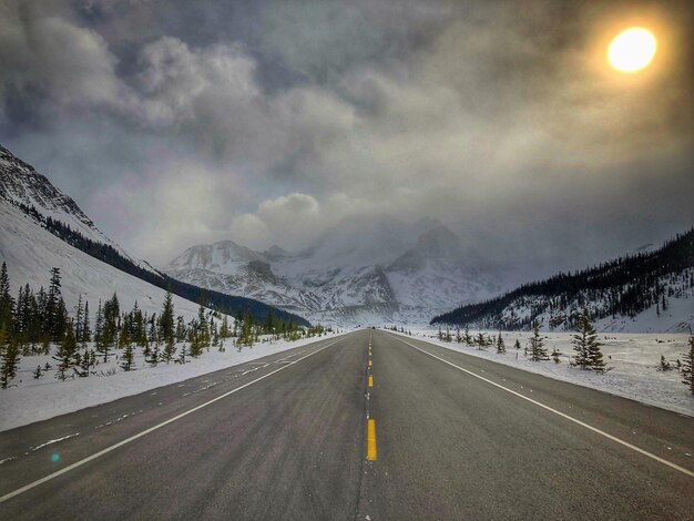 Photo road leading towards mountains against sky during winter