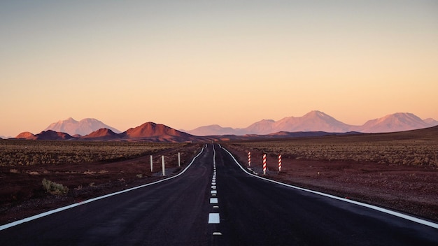 Road leading towards mountains against sky