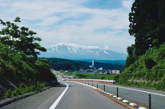 Road leading towards mountains against sky