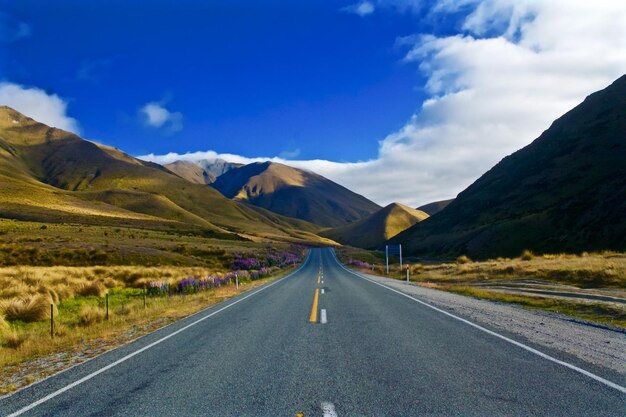 Road leading towards mountains against sky