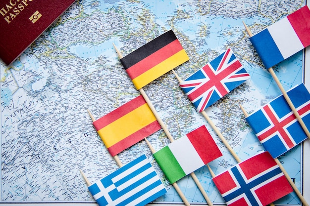 Road map national flags and passport on wooden table Top view