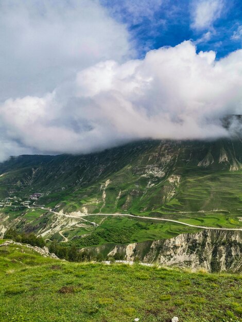 A road in the mountains of Dagestan with large mountains in the background and clouds Russia