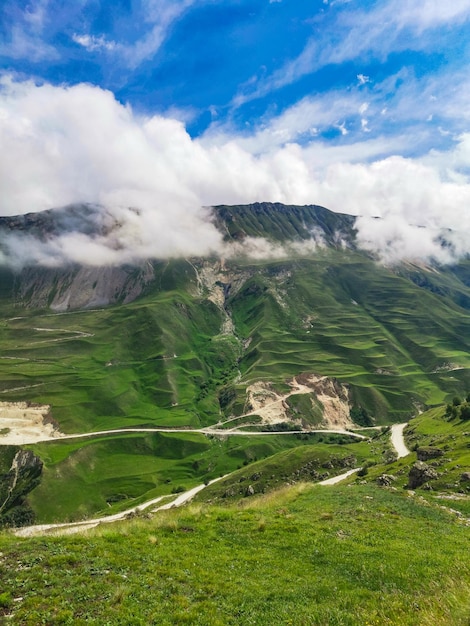 A road in the mountains of Dagestan with large mountains in the background and clouds Russia