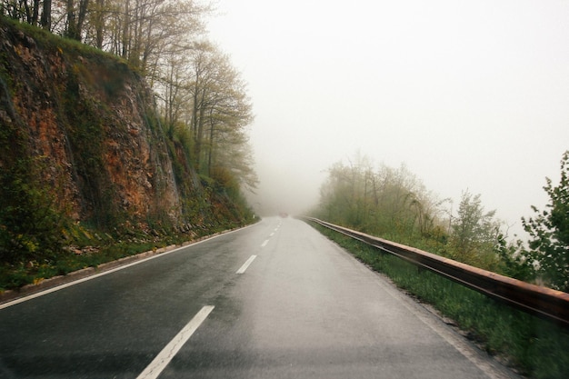 雨と霧の天気の山の中の道