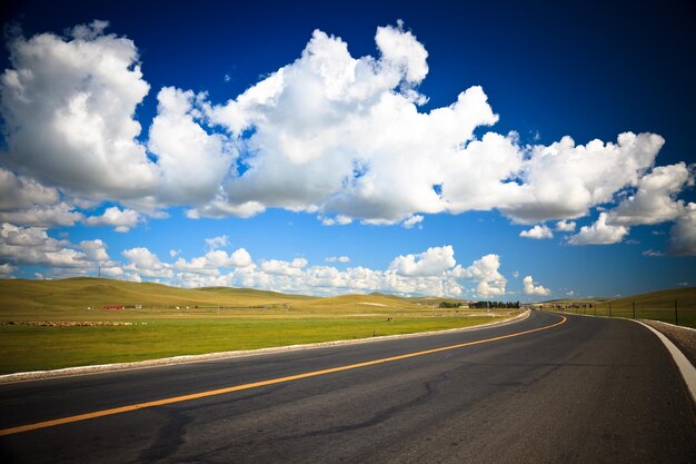 Road passing through land against sky