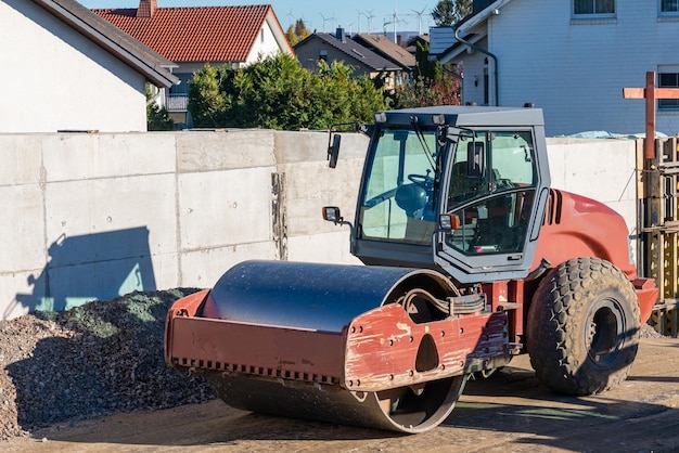 Road roller standing on a construction site near a concrete fence