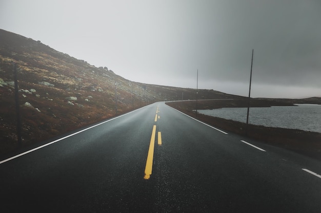 Road to scandinavian mountains at breathtaking national park on gloomy autumn day.