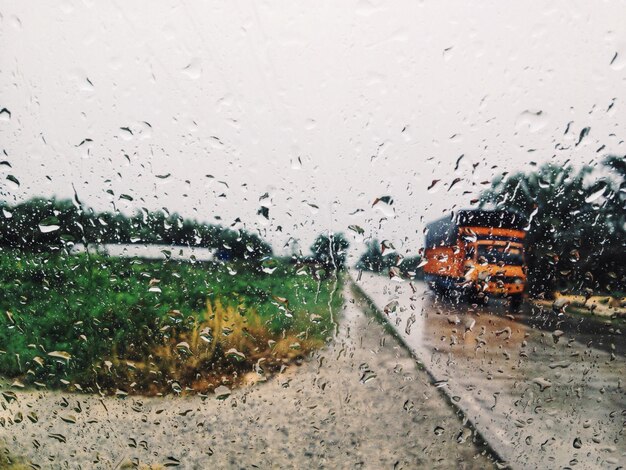 Road seen through wet car window