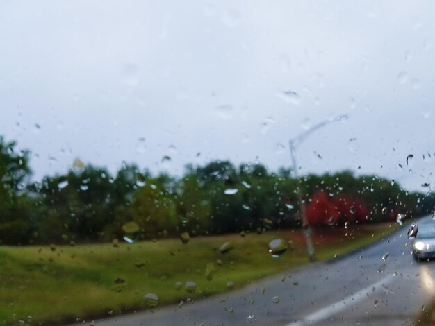 Road seen through wet window during rainy season