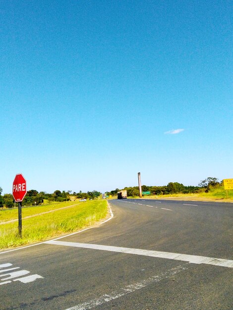 Road sign against clear blue sky