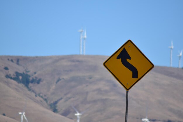 Road sign against clear blue sky
