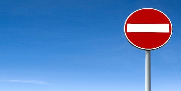 Road sign against clear blue sky