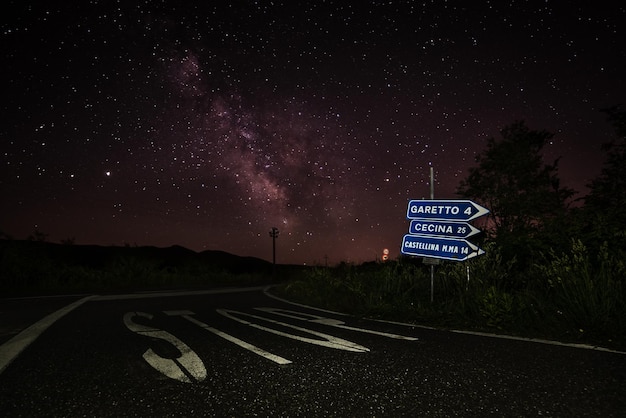 Road sign against sky at night