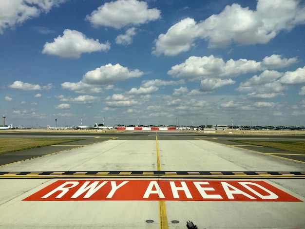 Foto segno stradale sulla pista dell'aeroporto contro il cielo