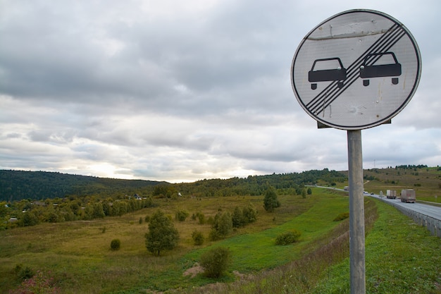 Road sign on the background of mountains and cloudy sky.