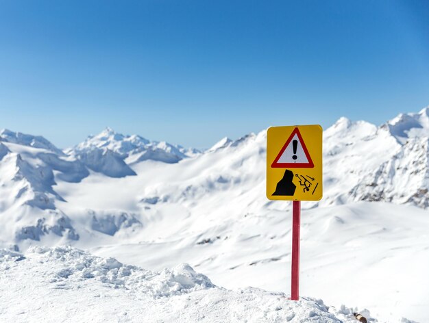 Foto segno stradale da montagne coperte di neve contro un cielo blu limpido