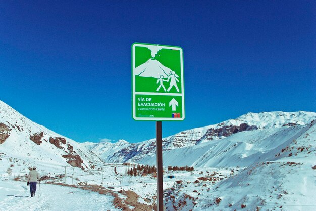 Foto segno stradale da montagne innevate contro un cielo blu limpido