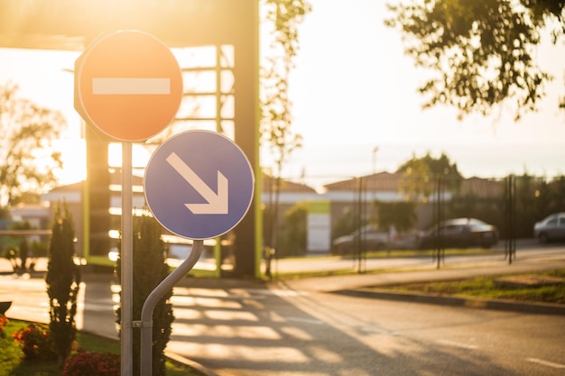 Road sign by street against sky in city